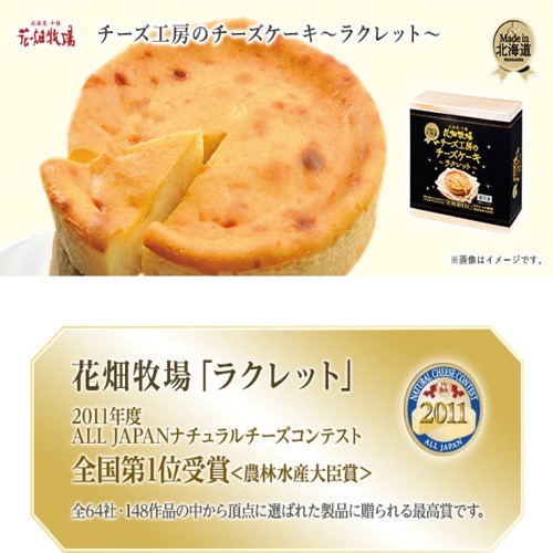 通販ショップ花畑牧場のチーズ工房のチーズケーキ、ラクレットの商品写真。写真にはラクレットチーズケーキがホールごと写っています。またチーズケーキが入る箱の写真も写っています。コメント葉２０１１年度ALL  JAPANナチュラルチーズコンテスト全国第1位受賞、農林水産大臣省。全６４社１４８作品の中から頂点に選ばれた製品に送られる最高賞です。と書かれています。